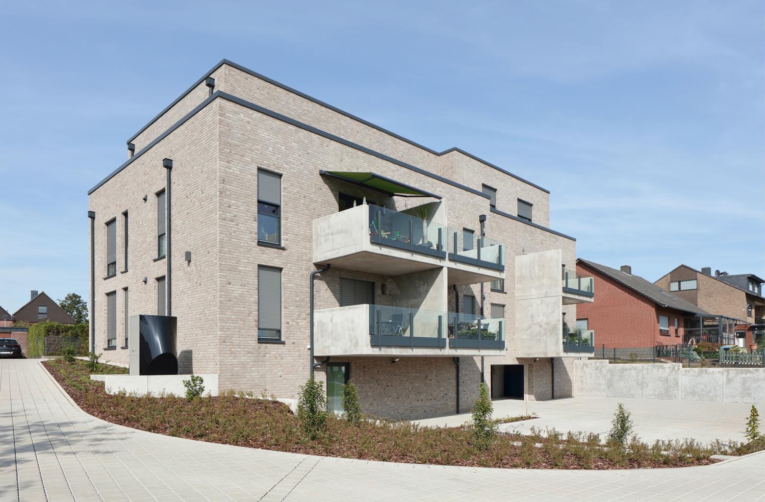 Ansicht auf ein Haus mit mehreren Balkon und Terrassen mit einem Sonnenschutz von Warema