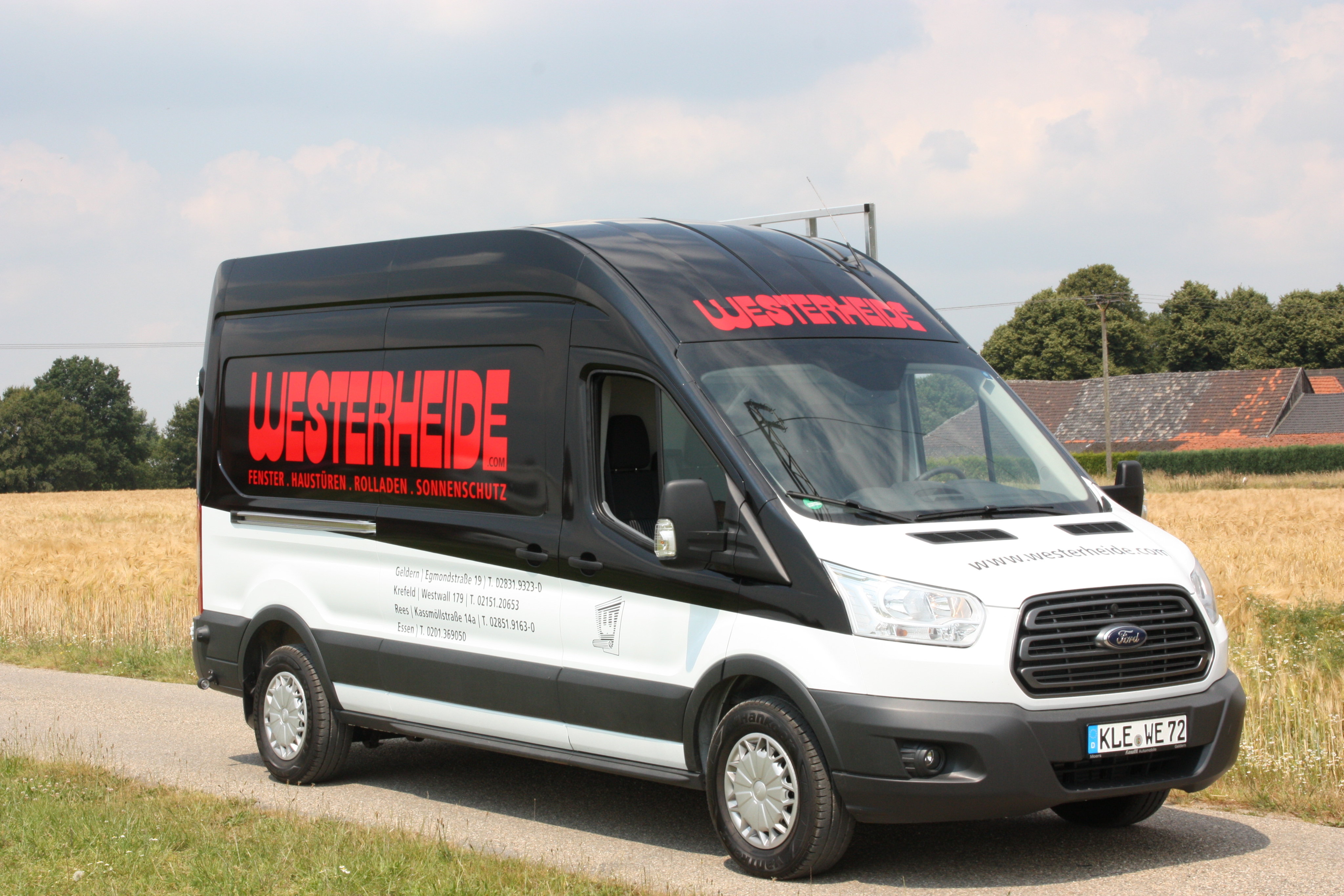 Bild eines Montagewagens der Westerheide GmbH auf einer Landstraße zwischen zwei Feldern.