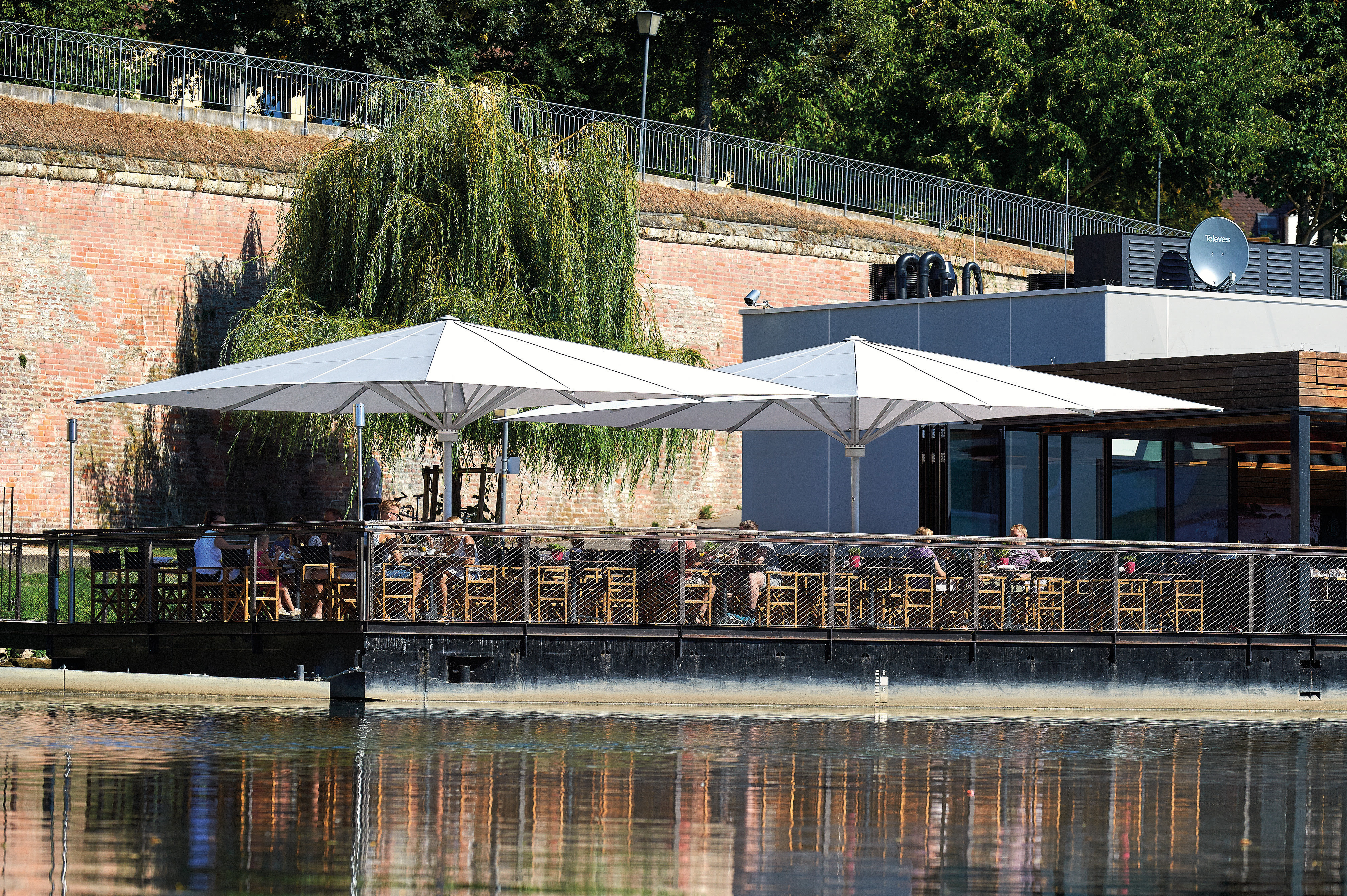 May Sonnenschirme auf einer gastronomischen Außenterrasse am Wasser